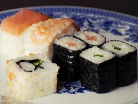 Sushi rolls and nigiri on a blue and white plate